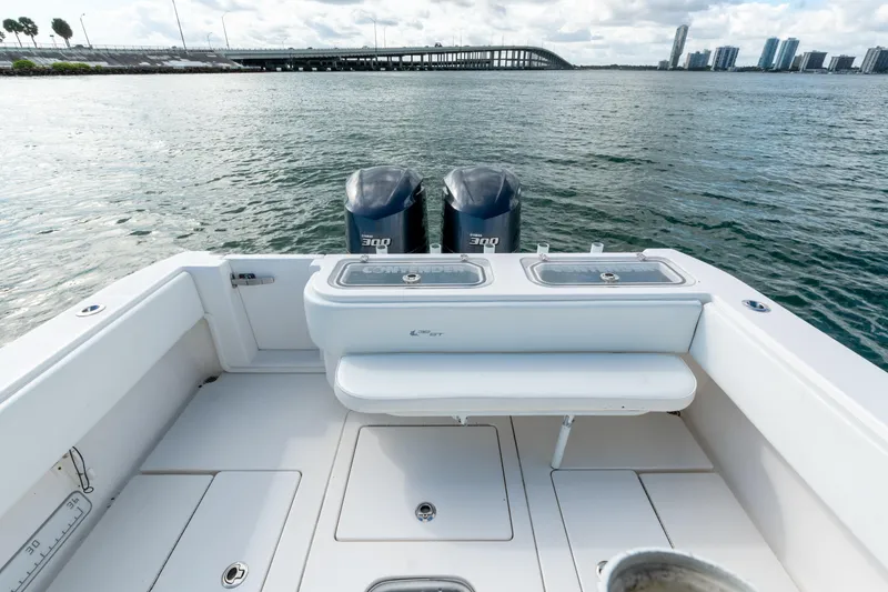 Slide: The Image of 2019 Contender 32 ST boat with dual engines, open deck, and scenic waterfront view. - 20