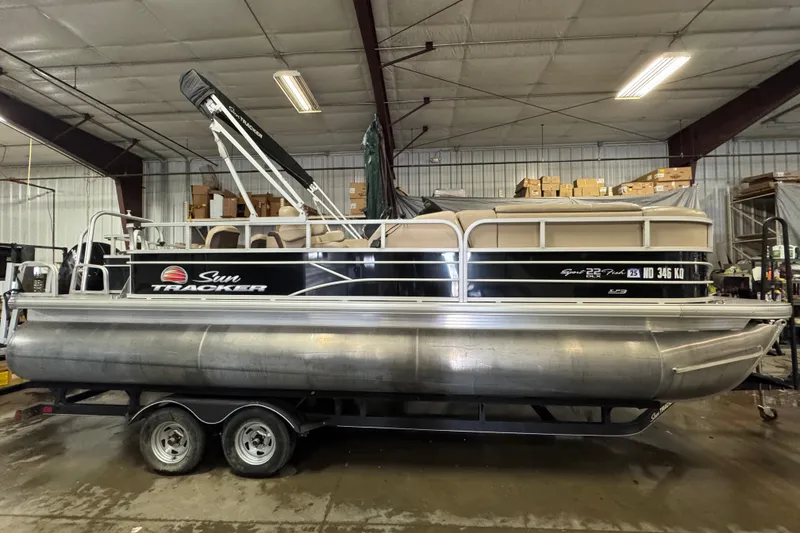 Slide: The Image of 2018 Sun Tracker SportFish 22 XP3 pontoon boat in a warehouse setting. - 3