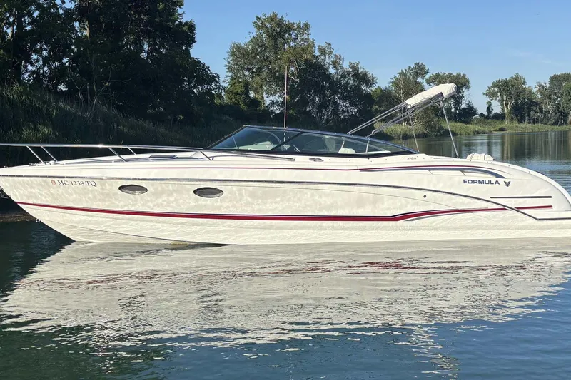 The Image of 2012 Formula 310 Sun Sport boat on calm water, surrounded by trees. - 0