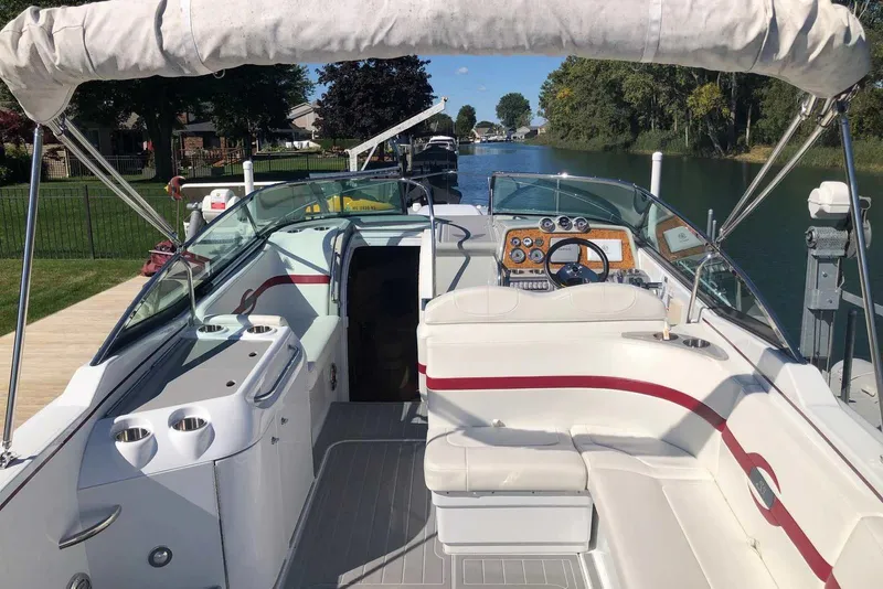 Slide: The Image of 2012 Formula 310 Sun Sport boat interior with white seating and dashboard, docked by a canal. - 12