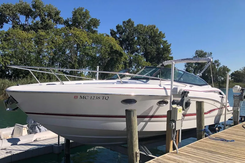 Slide: The Image of 2012 Formula 310 Sun Sport boat docked by a serene lake with lush trees. - 2