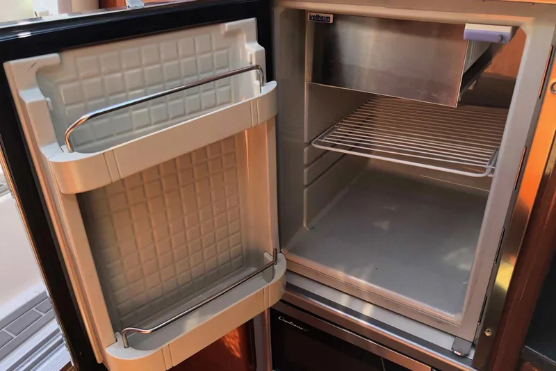 Slide: The Image of Open refrigerator inside a 2012 Formula 310 Sun Sport boat, showing empty shelves. - 28