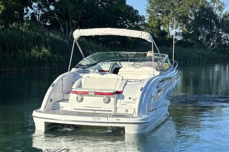 Slide: The Image of 2012 Formula 310 Sun Sport boat cruising on a serene waterway. - 4