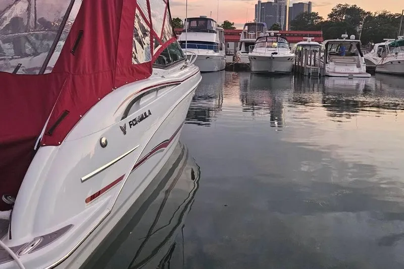 Slide: The Image of 2012 Formula 310 Sun Sport boat docked with red canopy, surrounded by other boats at sunset. - 40