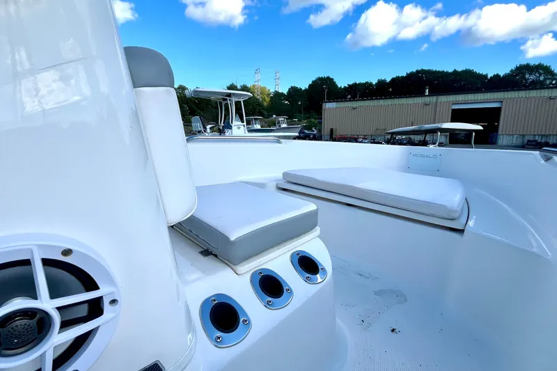 Slide: The Image of 2021 Robalo R160 Center Console boat interior with cushioned seating and rod holders. - 17