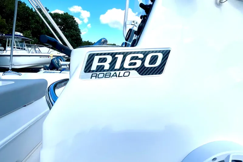 Slide: The Image of 2021 Robalo R160 Center Console boat with sleek design and branding. - 5