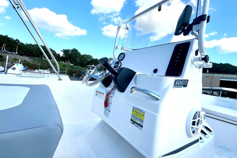 Slide: The Image of 2021 Robalo R160 Center Console boat with steering wheel and control panel. - 6