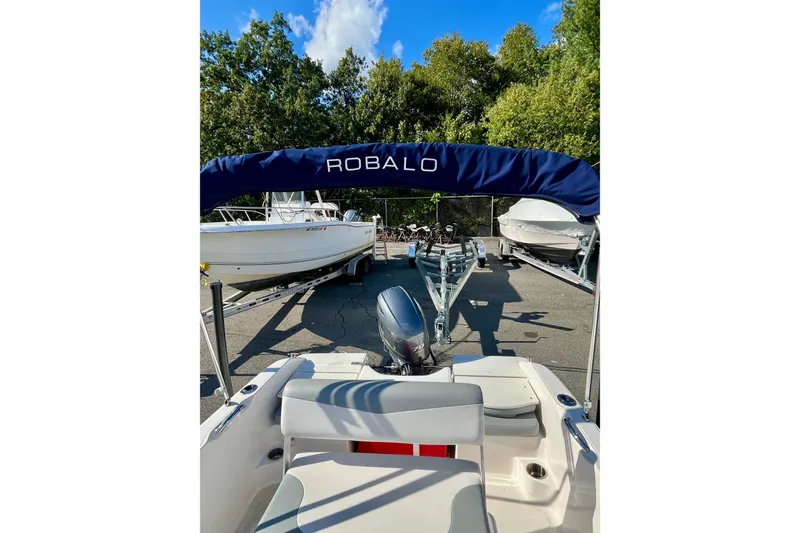 Slide: The Image of 2021 Robalo R160 Center Console boat with blue canopy, parked on a trailer. - 9