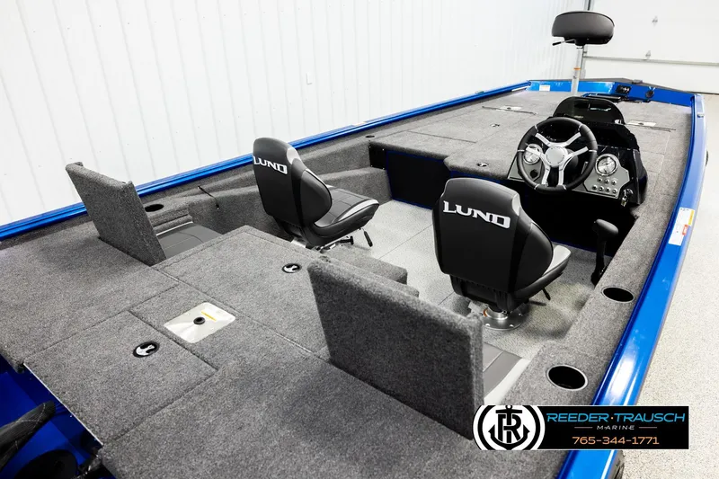 Slide: The Image of 2026 Lund 1875 Renegade boat interior with steering console and seating, showcased by Reeder-Trausch Marine. - 10