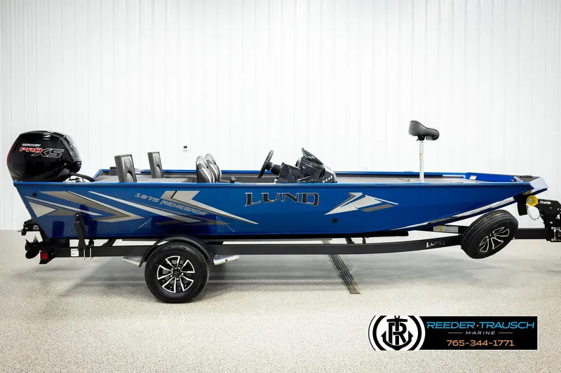 Slide: The Image of 2026 Lund 1875 Renegade boat in blue, side view, on trailer, with Mercury Pro XS engine. - 3