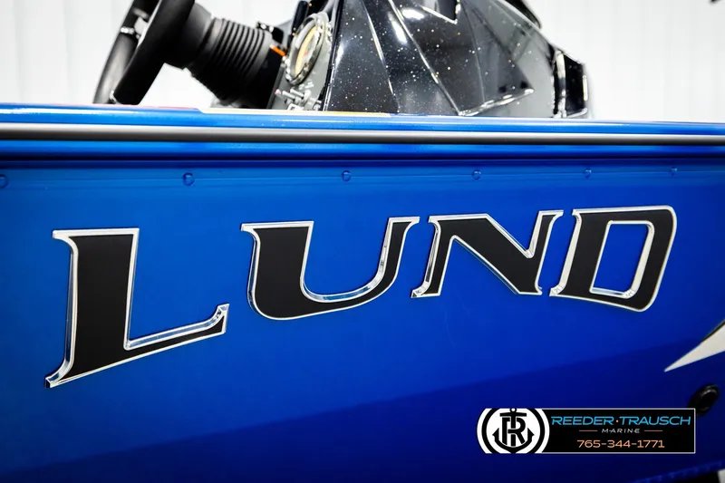 Slide: The Image of 2026 Lund 1875 Renegade boat, blue exterior with bold logo, Reeder-Trausch Marine branding. - 48