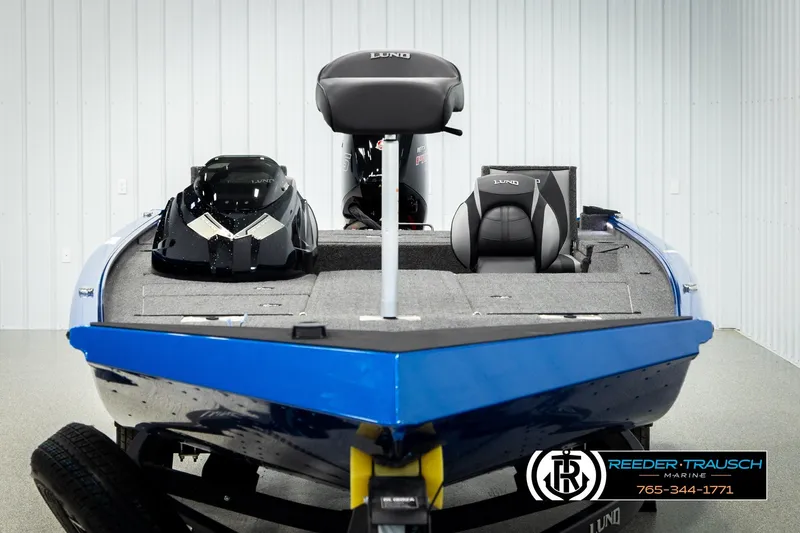 Slide: The Image of 2026 Lund 1875 Renegade boat in showroom, featuring sleek design and modern seating. - 6