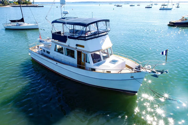 The Image of 1988 Grand Banks 42 Classic yacht on serene water with sailboats in the background. - 0