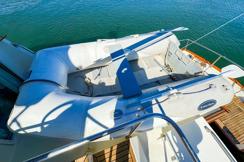Slide: The Image of Inflatable dinghy on 1988 Grand Banks 42 Classic yacht deck, moored on calm water. - 10