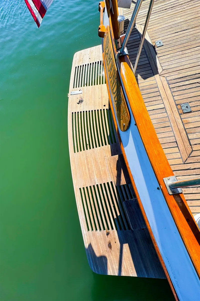 Slide: The Image of 1988 Grand Banks 42 Classic yacht stern with wooden swim platform on calm water. - 11