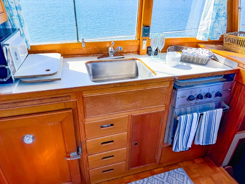 Slide: The Image of Galley kitchen in 1988 Grand Banks 42 Classic yacht with sink, stove, and wooden cabinetry. - 14