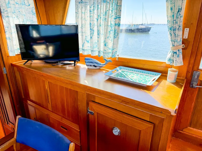 Slide: The Image of 1988 Grand Banks 42 Classic interior with TV, nautical decor, and ocean view. - 15
