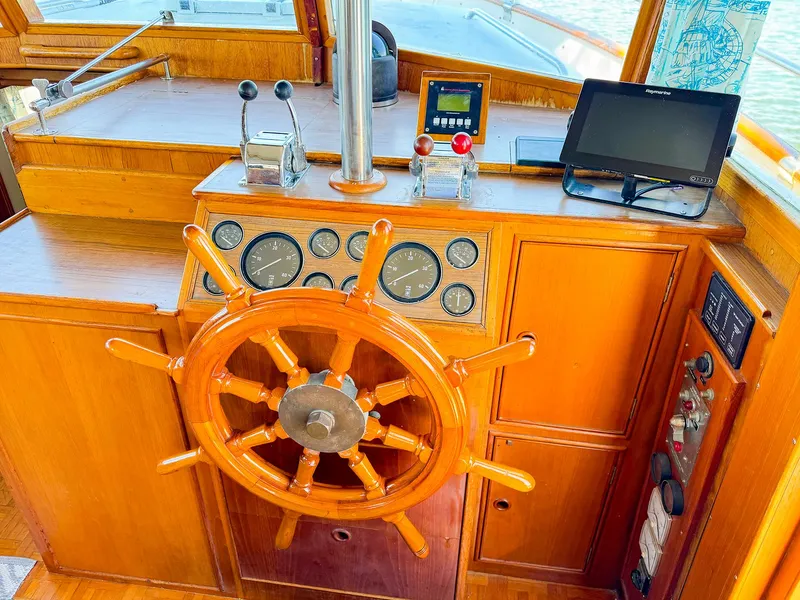 Slide: The Image of Wooden helm of 1988 Grand Banks 42 Classic yacht with navigation instruments. - 19