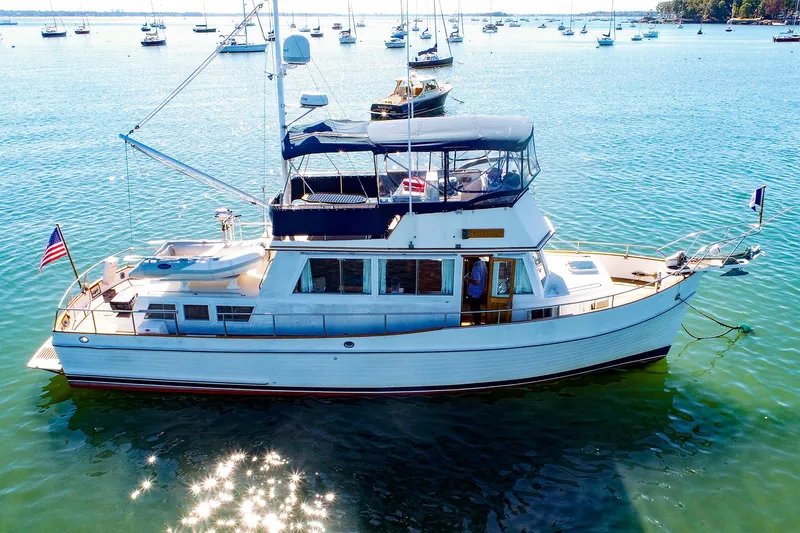 Slide: The Image of 1988 Grand Banks 42 Classic yacht on serene water with distant boats. - 2