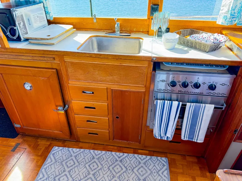 Slide: The Image of Galley kitchen in 1988 Grand Banks 42 Classic yacht with wood cabinetry and stainless steel sink. - 21