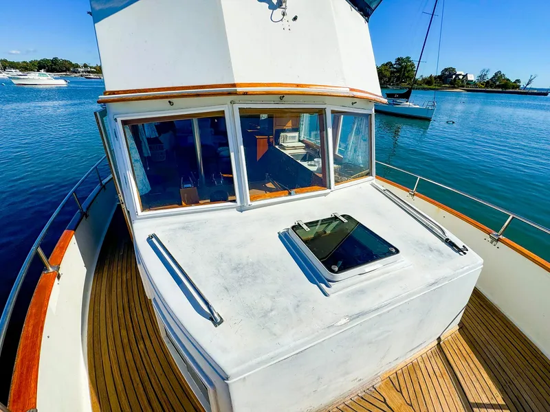 Slide: The Image of 1988 Grand Banks 42 Classic yacht on calm water, showcasing deck and cabin windows. - 3