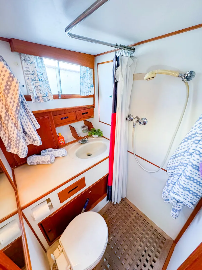 Slide: The Image of 1988 Grand Banks 42 Classic yacht bathroom with shower, sink, and wooden cabinetry. - 30