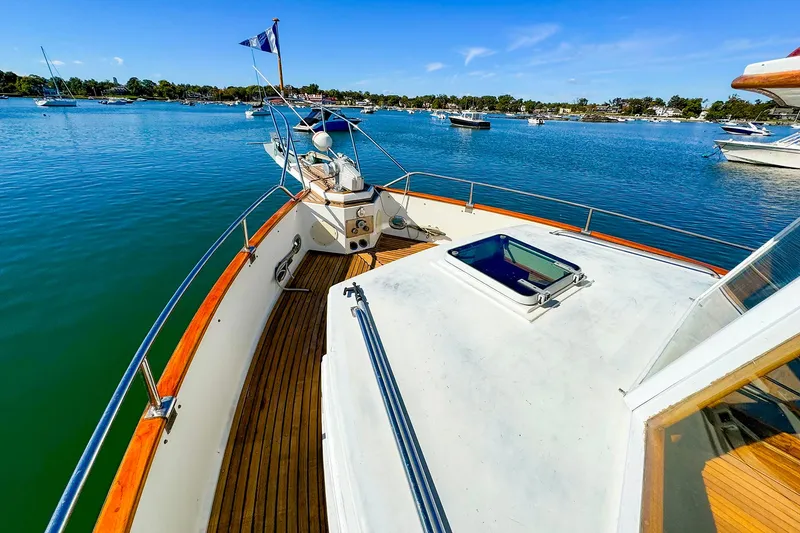 Slide: The Image of 1988 Grand Banks 42 Classic yacht on serene water, showcasing deck and scenic view. - 4