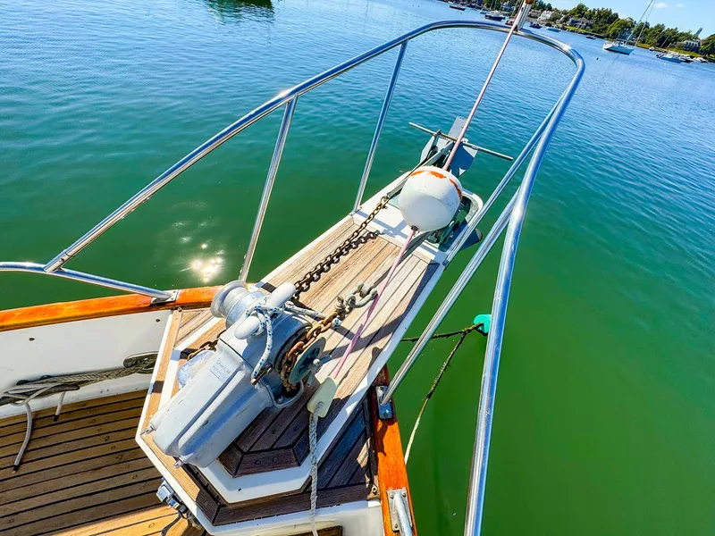 Slide: The Image of Grand Banks 42 Classic 1988 yacht bow with anchor, on calm green water. - 5