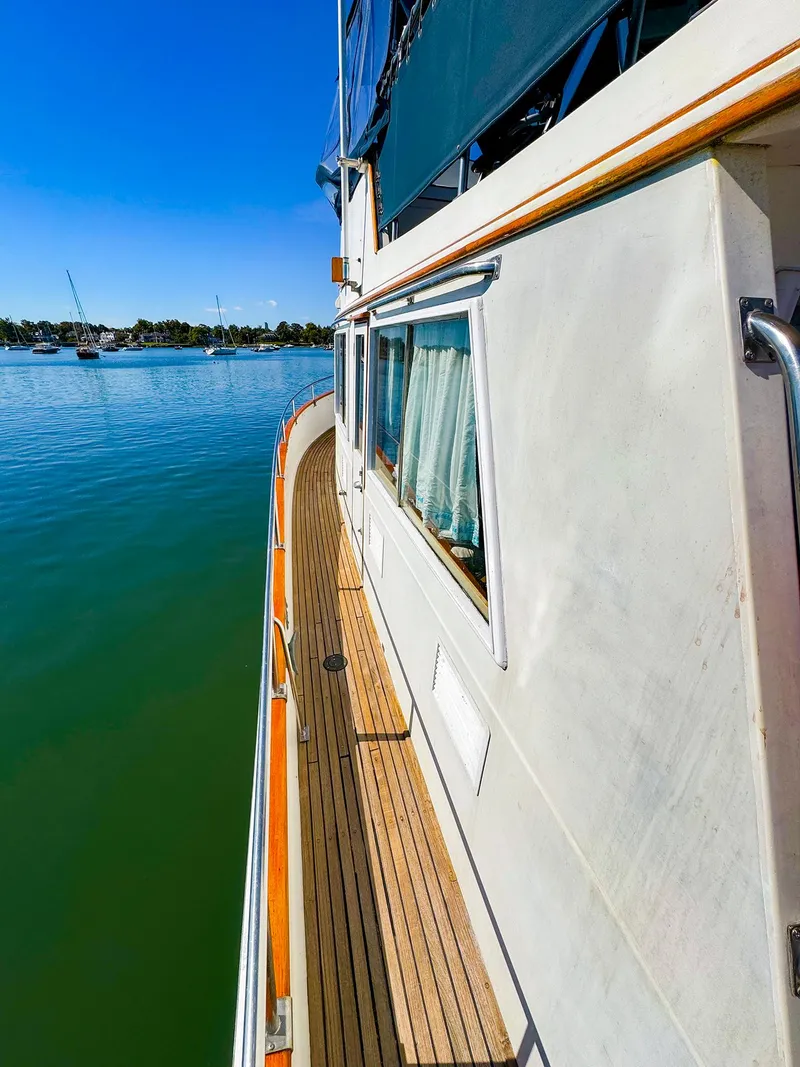 Slide: The Image of 1988 Grand Banks 42 Classic yacht on calm water, side deck view. - 6