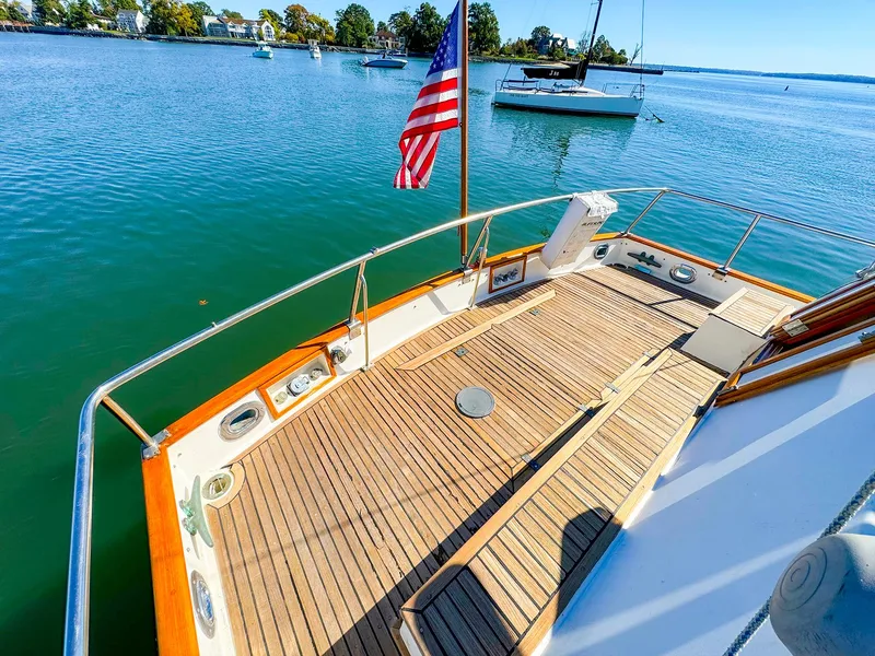 Slide: The Image of 1988 Grand Banks 42 Classic yacht deck with American flag, moored on calm water. - 9