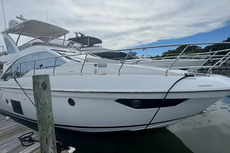 Slide: The Image of 2021 Azimut 50 Flybridge yacht docked at marina under cloudy sky. - 1