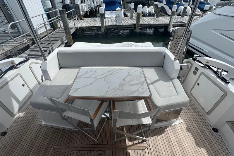 Slide: The Image of Azimut 50 Flybridge 2021 yacht with elegant outdoor seating and marble table. - 11