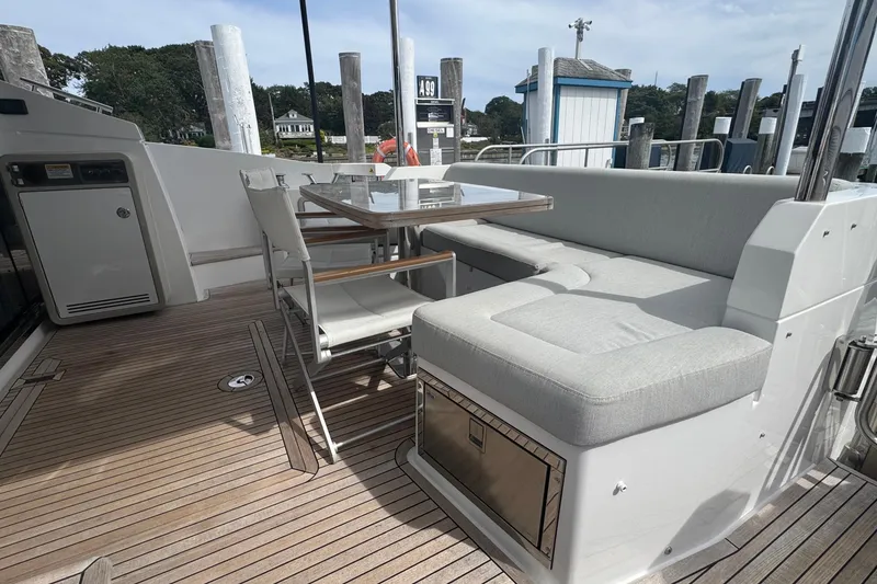 Slide: The Image of Azimut 50 Flybridge 2021 yacht deck with seating and table, docked at marina. - 13