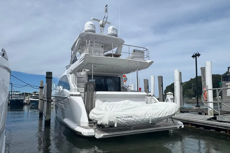 Slide: The Image of Azimut 50 Flybridge 2021 yacht docked at marina, rear view with covered tender. - 2