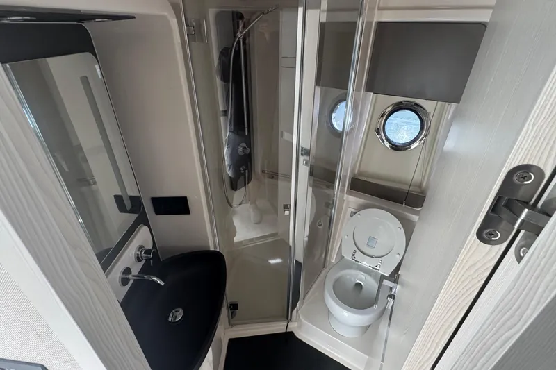 Slide: The Image of Luxurious bathroom in 2021 Azimut 50 Flybridge yacht with modern fixtures and porthole window. - 34