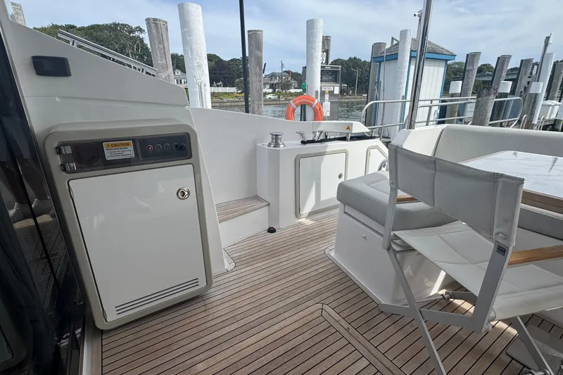 Slide: The Image of Azimut 50 Flybridge 2021 yacht deck with seating and storage, docked at marina. - 6