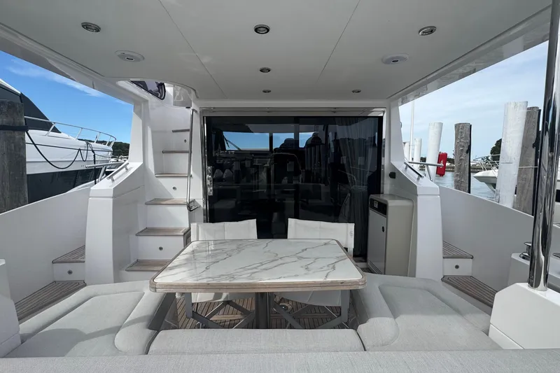 Slide: The Image of Luxurious 2021 Azimut 50 Flybridge yacht with elegant outdoor seating and marble table. - 9