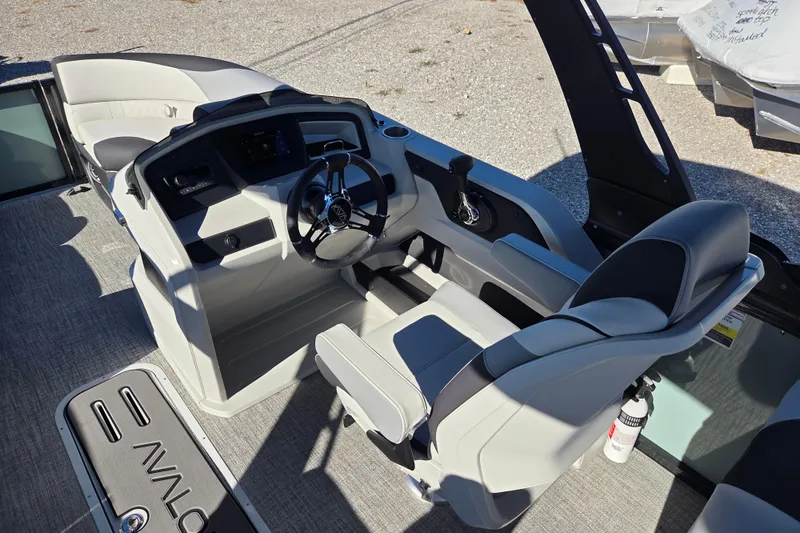 Slide: The Image of 2026 Avalon Platinum LSZ 2385 Quad Lounger boat interior with steering console and seating. - 8