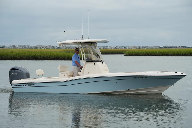 The Image of 2023 Grady-White 251 Coastal Explorer boat on calm water, with lush greenery in the background. - 0