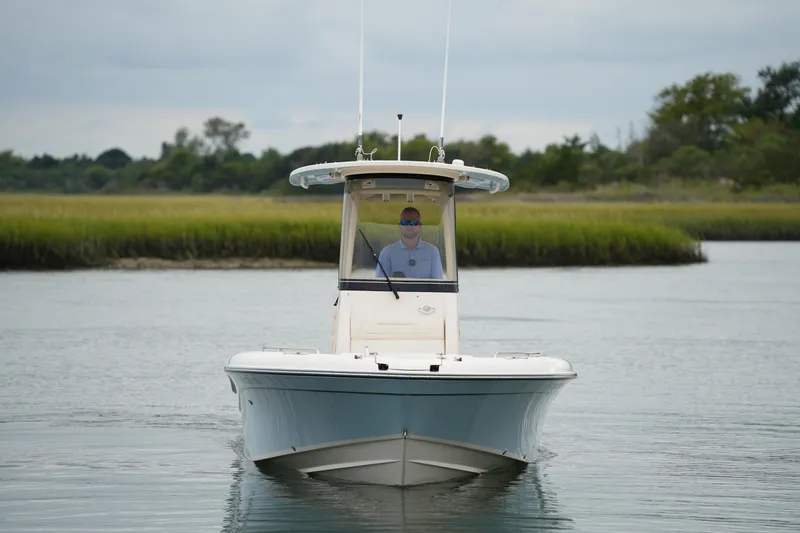 Slide: The Image of 2023 Grady-White 251 Coastal Explorer boat on calm water, with lush greenery in background. - 14