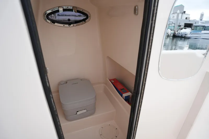 Slide: The Image of 2023 Grady-White 251 Coastal Explorer boat interior with portable toilet and storage. - 37