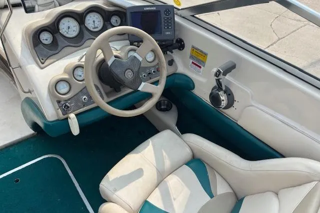 Slide: The Image of 2000 Glastron GX 180 boat cockpit with steering wheel, gauges, and seating. - 10