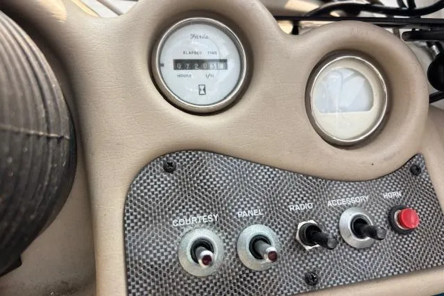 Slide: The Image of Dashboard of a 2000 Glastron GX 180 boat with switches and gauges. - 13