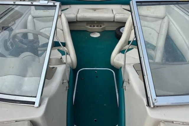 Slide: The Image of 2000 Glastron GX 180 boat interior with teal carpet and white seating. - 15
