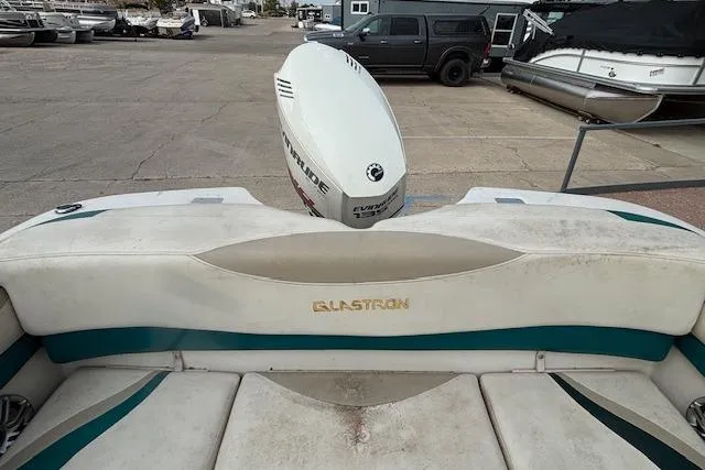Slide: The Image of 2000 Glastron GX 180 boat with Evinrude motor, parked in a marina. - 17