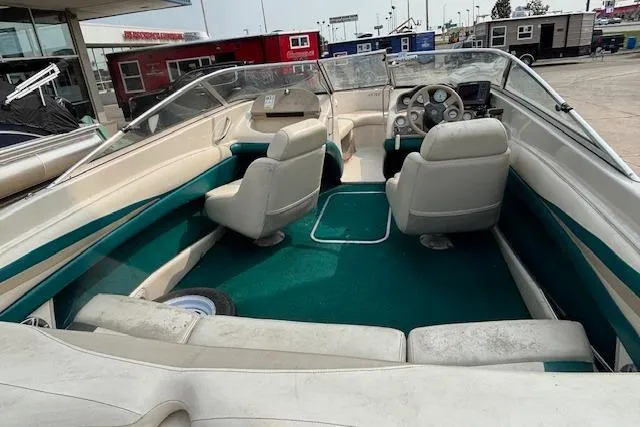 Slide: The Image of 2000 Glastron GX 180 boat interior with green carpet and white seating. - 6