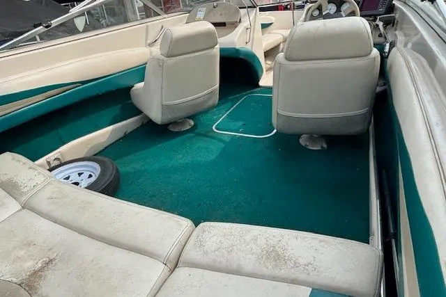 Slide: The Image of Interior of a 2000 Glastron GX 180 boat with teal carpet and white seats. - 7