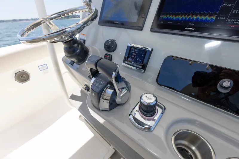 Slide: The Image of Control panel of a 2016 Boston Whaler 330 Outrage boat with steering wheel and navigation screens. - 11