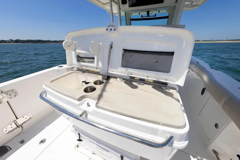 Slide: The Image of 2016 Boston Whaler 330 Outrage boat interior with open storage and cup holders. - 12