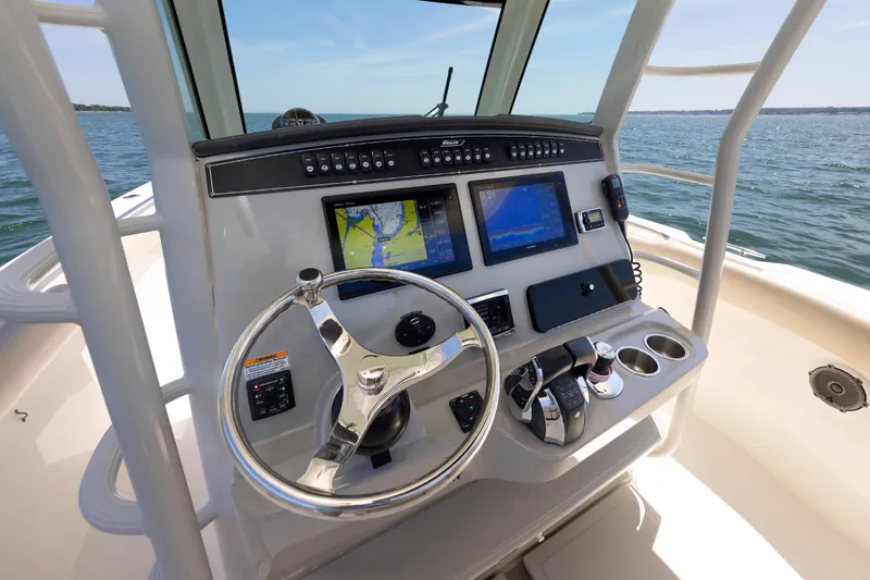 Slide: The Image of Control panel of 2016 Boston Whaler 330 Outrage boat with navigation screens and steering wheel. - 2
